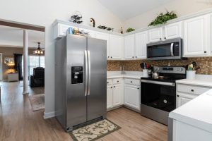 Bright kitchen showcasing stainless steel appliances and white cabinets.
